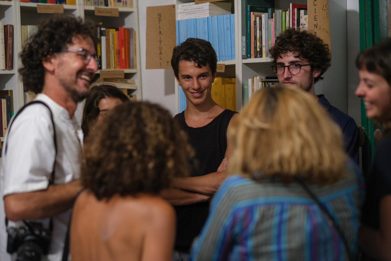 Persone che dialogano tra gli scaffali della biblioteca durante un evento