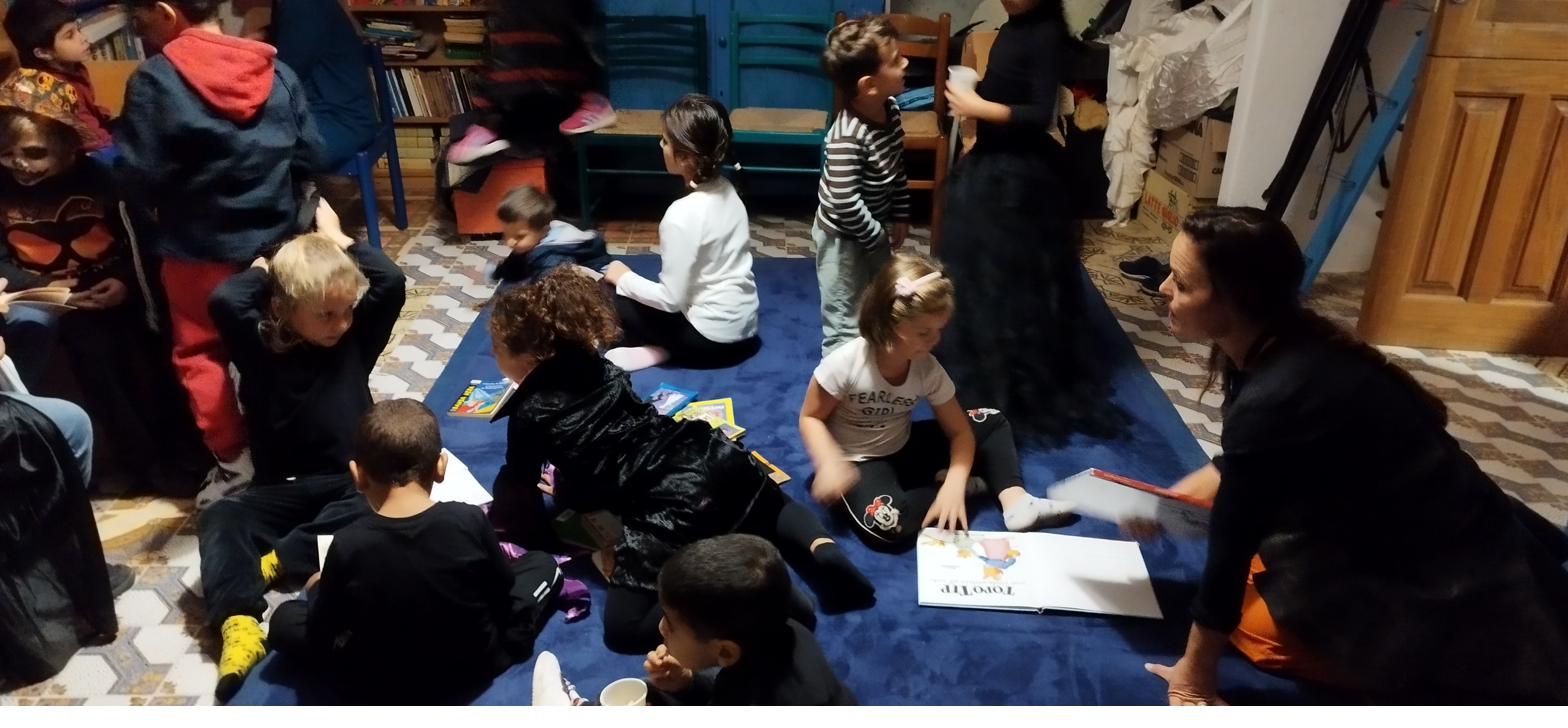 Bambini seduti in cerchio durante un laboratorio di lettura in biblioteca